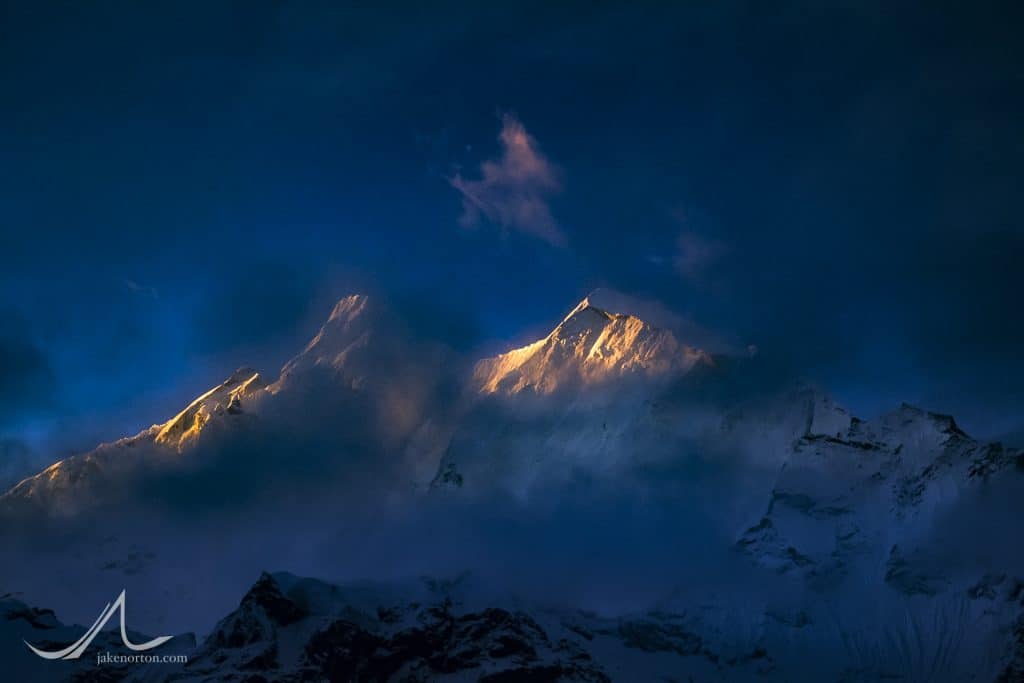 The steep and jagged flanks of Chomo Lonzo (7804 meters) catch morning sun in the notoriously misty and ethereal Kangshung Valley on the east side of Mount Everest, Tibet.