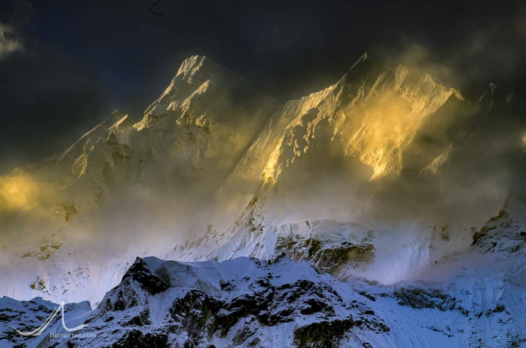 The steep and jagged flanks of Chomo Lonzo (7804 meters) catch morning sun in the notoriously misty and ethereal Kangshung Valley on the east side of Mount Everest, Tibet.