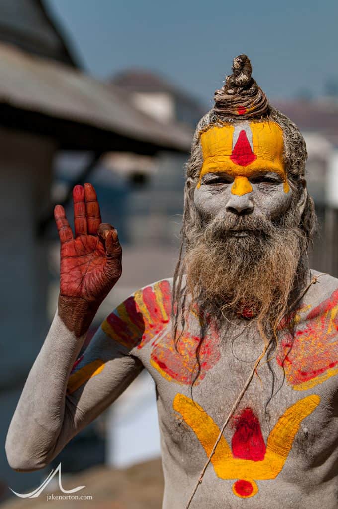 A sadhu, or Hindu holy man, showing the "om" symbol with his right hand at Pashupatinath, Kathmandu, Nepal.