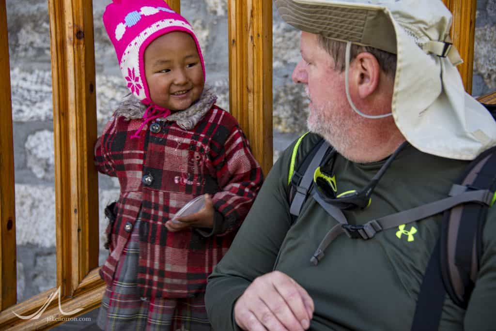 Art Adams sharing with a young Nepali girl in Monjo, Solu Khumbu, Nepal.