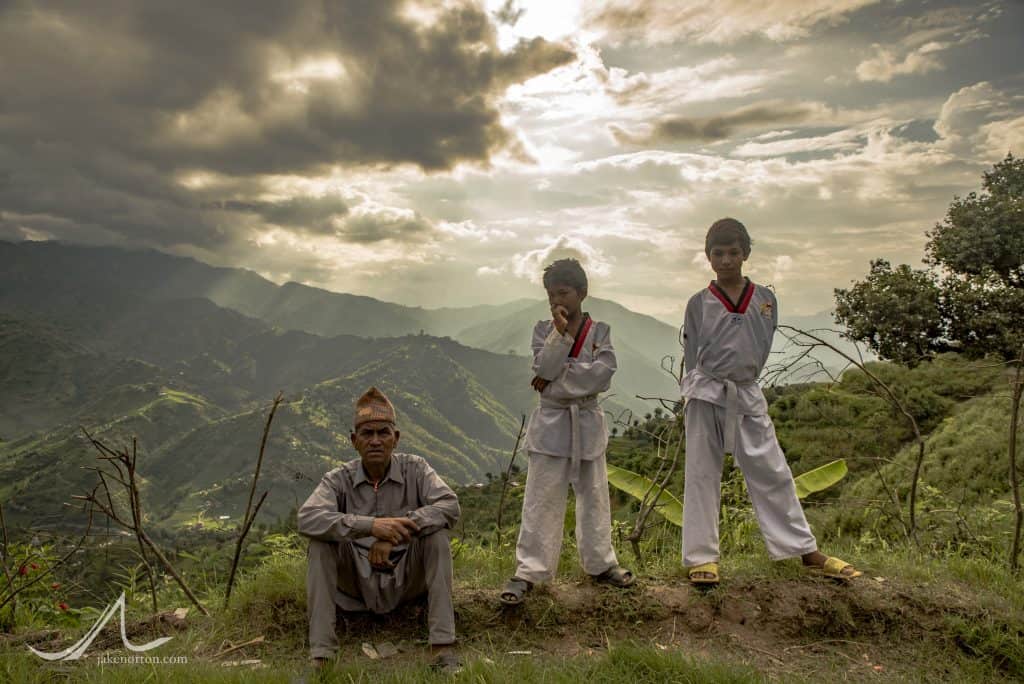 Boys from Mankhu, Dhading, Nepal, rest in the monsoon afternoon with their father after taekwondo practice.