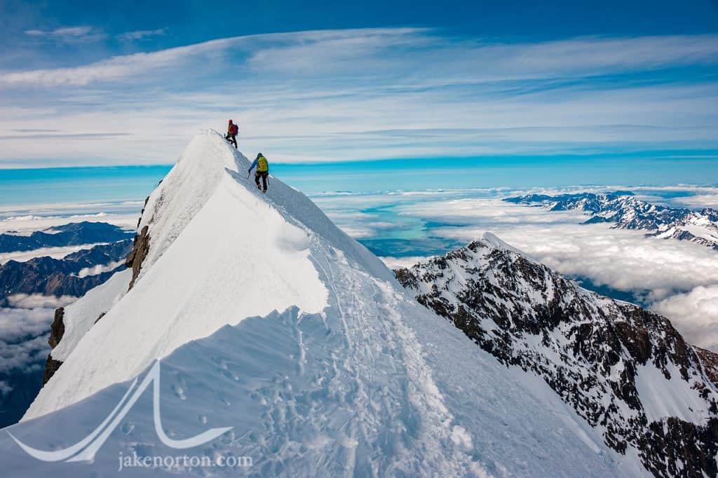 David Morton belays Charley Mace up to the steep summit of Aoraki (Mount Cook), New Zealand.