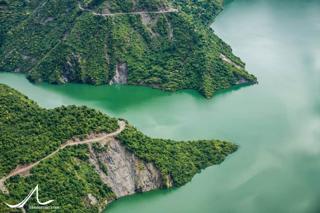 Roads scratch along the hillsides above the Tehri Lake, a manmade and controversial lake created by the Tehri Dam on the Bhagirathi River, which is the initial source river for the Ganges. After the dam, the Bhagirathi flows down to join the Alaknanda at Devprayag, and the Ganges River is born.