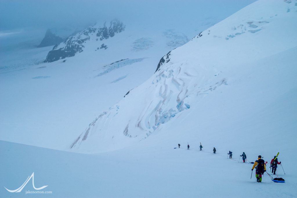 A team of climbers descends from The Trident down toward the Compass Glacier on the Shackleton crossing of South Georgia.