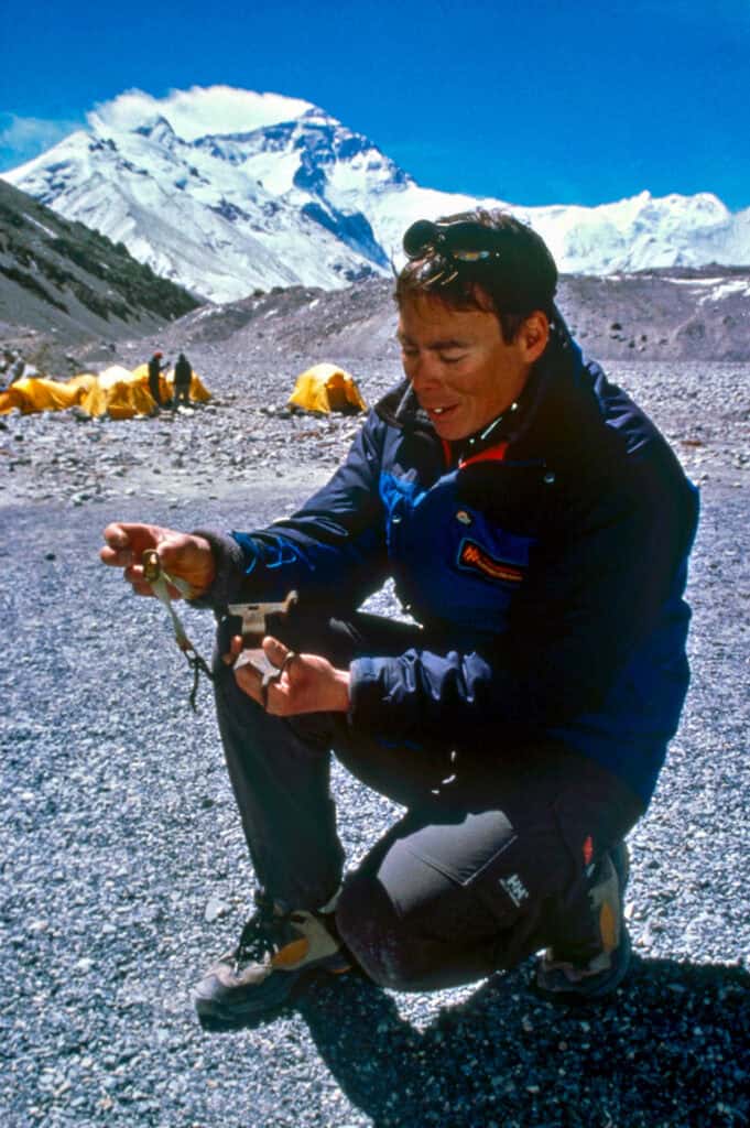 At Rongbuk Basecamp, Brent Okita examines a partial crampon recovered from the 1922 Camp III on the East Rongbuk Glacier on Mount Everest.
