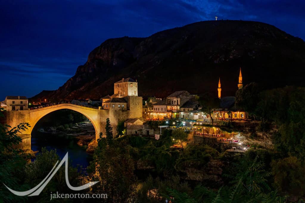 Stari Most at dusk, beneath the Millennium Cross on Hum Hill, erected in 2000.